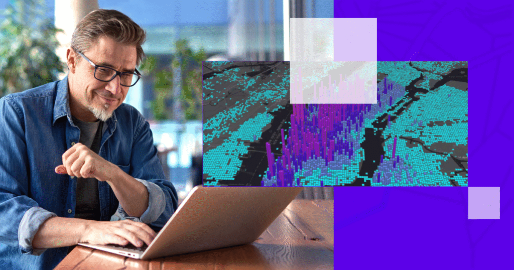 Homem com óculos trabalha em laptop enquanto observa mapa 3D de dados geoespaciais em tons de azul e roxo, representando análise avançada com inteligência geográfica.