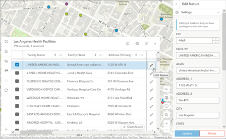 Interface de edição de atributos de uma instalação de saúde em Los Angeles, com campos editáveis como endereço, cidade e estado, ao lado do mapa.