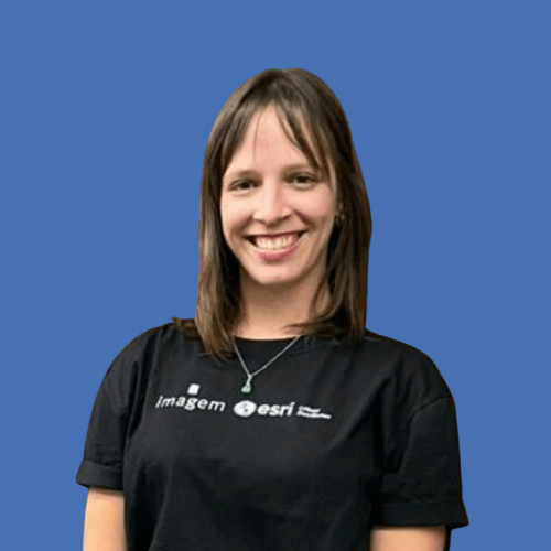 Fotografia de Carolina Rovira, Analista de Sucesso do Cliente da Imagem Geosistemas, usando uma camiseta preta com a logo da Imagem e Esri em fundo azul.