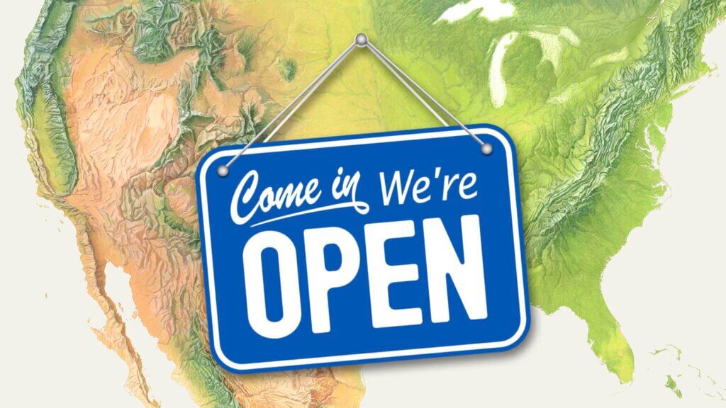 Mapa topográfico detalhado dos Estados Unidos com uma placa azul pendurada sobre ele, com o texto 'Come in, We're Open' em letras brancas, simbolizando uma empresa aberta ao público. A placa é colocada de forma proeminente sobre o mapa, destacando as principais regiões geográficas do país, incluindo a Costa Oeste, Meio-Oeste e Costa Leste