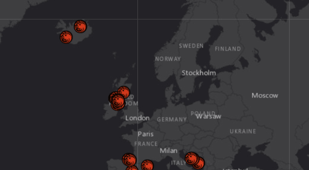 Mapa da Europa com fundo escuro exibindo pontos de calor destacados em vermelho, localizados principalmente no Reino Unido, Islândia, França e Itália. As marcações indicam eventos geográficos ou ambientais, como atividade sísmica ou queimadas. Cidades como Londres, Paris, Estocolmo e Moscou estão rotuladas.