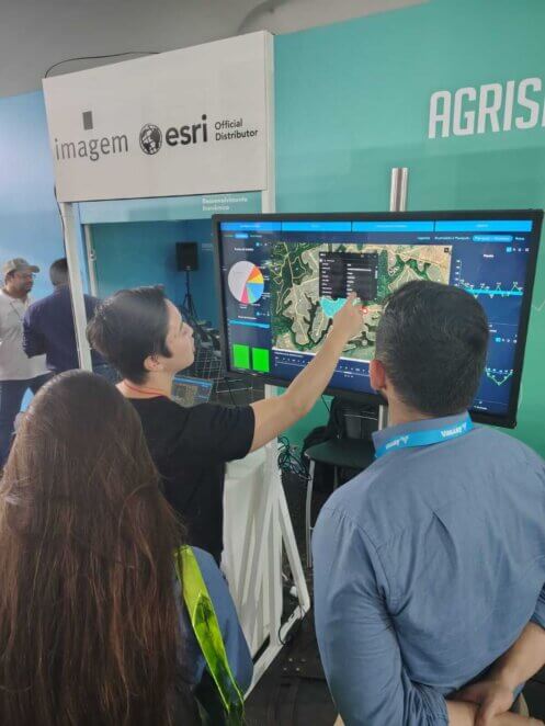 Especialista da Imagem Geosistemas demonstra painel de inteligência geográfica com ArcGIS a visitantes da Agrishow 2025.