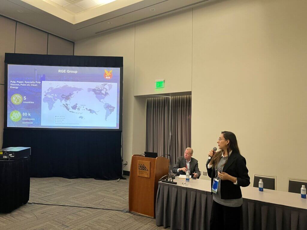 Representante da Bracell apresenta o alcance global do grupo RGE em uma palestra na Esri UC 2025, com mapa-múndi ao fundo e destaque para atuação em 5 países e 80 mil colaboradores.