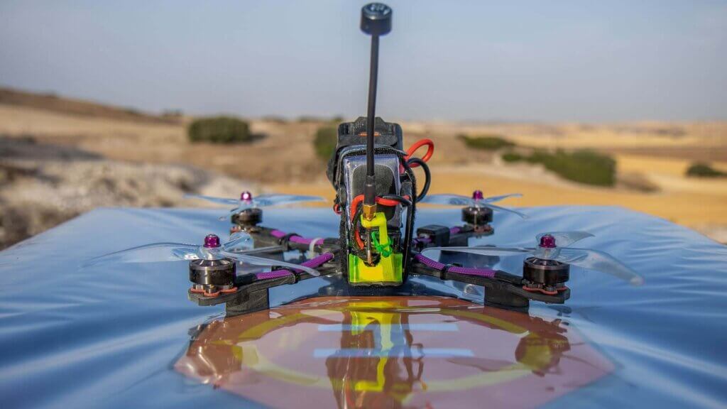 Drone em voo sobre uma área de montanha, representando o uso de drones combinados ao GIS para logística, planejamento de obras e monitoramento ambiental